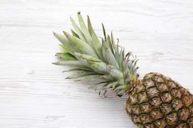 Beyaz ahşap zemin üzerinde büyük Olgun ananas. Yukarıdan. Üstten görünüm.