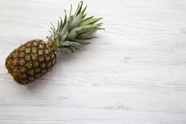 Olgun ananas kopya alanı ile beyaz ahşap zemin üzerinde. Yukarıdan. Üstten görünüm.