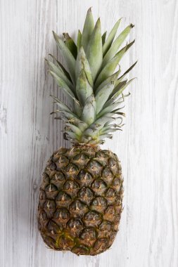 Beyaz ahşap zemin, üstten görünüm üzerinde büyük Olgun ananas. Yukarıdan. 