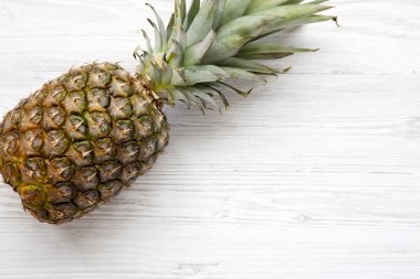 Büyük Olgun ananas kopya alanı ile beyaz ahşap zemin üzerinde. Yukarıdan. Üstten görünüm.