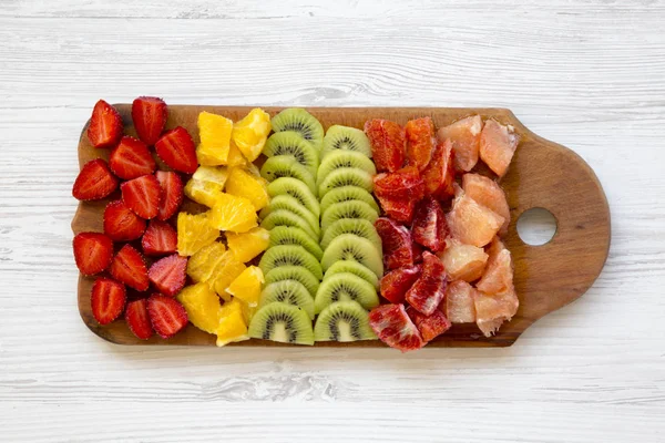 Frutas Picadas Dispostas Tábua Corte Sobre Fundo Madeira Branca Vista — Fotografia de Stock