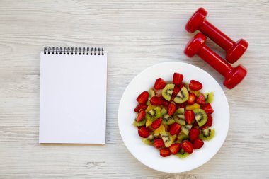 Dambıl ve defter, üstten görünüm ile taze meyve salatası. Düz yatıyordu. Kopya alanı.