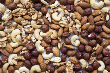 Beyaz ahşap zemin üzerinde fındık (kaju fıstığı, fındık, ceviz, badem), karışık görünümü top. Düz yatıyordu.