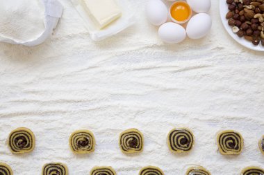 Haşhaş tohumu, Kuru üzüm ve fındık Beyaz ahşap masa üzerinde çiğ kurabiye. Kurabiye yapmak için malzemeler. Üstten görünüm, yat. Kopya alanı.