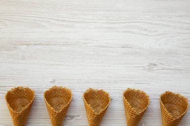 Dondurma waffle koniler Beyaz ahşap zemin, düz üzerinde yatıyordu. Yukarıdan görünüm üst. Metin için yer.