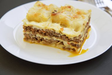 Geleneksel et lazanya bir beyaz karanlık tablo tabağa yuvarlak. Yan görünümü. Yakın çekim.
