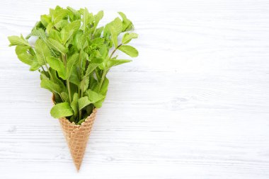 Beyaz ahşap zemin, üstten görünüm üzerine nane ile gözleme tatlı dondurma külahı. Kopya alanı. 