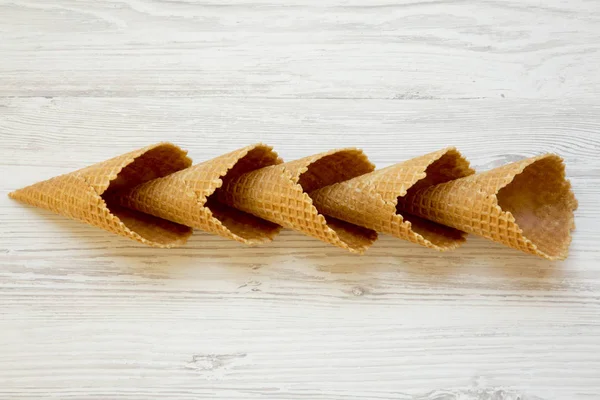 Creative layout of waffle sweet cones on a white wooden background. Top view. Flat lay, from above.