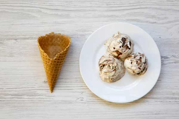 Üstten görünüm, dondurma tatlı koni ile beyaz tabak içinde. Tepegöz, yat. Yukarıdan.