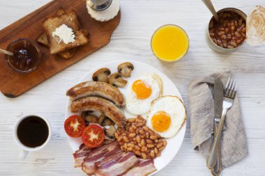 Tam İngiliz kahvaltısı, üstten görünüm. Beyaz ahşap arka plan. Düz yatıyordu. Yukarıda, ek yükü.