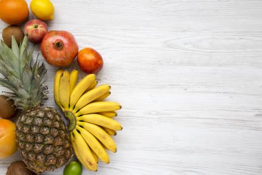 Tropikal meyve gelen yukarıdaki Beyaz ahşap zemin üzerinde. Uzay kopyalayın. Düz yatıyordu.