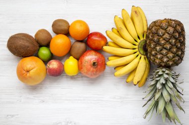 Tropikal meyve Beyaz ahşap yüzey, en iyi görünüm üzerinde. Düz-lay.