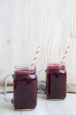 Berry yüzlü beyaz ahşap arka planda, yan görünümü ile cam kavanozlar. Kopya alanı.