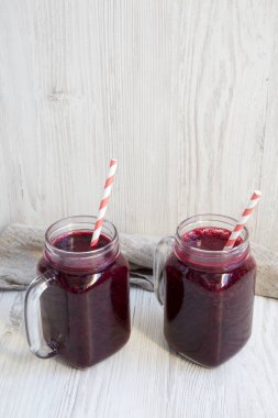 Berry yüzlü beyaz tahta masada yan görünümü ile cam kavanozlar. Kopya alanı.