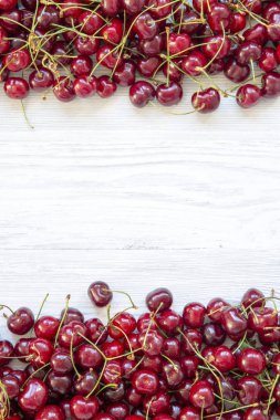 Beyaz ahşap arka plan, üstten görünüm üzerinde taze olgun kiraz. Düz yatıyordu. Kopya alanı.