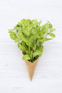 Beyaz ahşap zemin, üstten görünüm üzerine nane ile gözleme tatlı dondurma külahı. Düz yatıyordu.