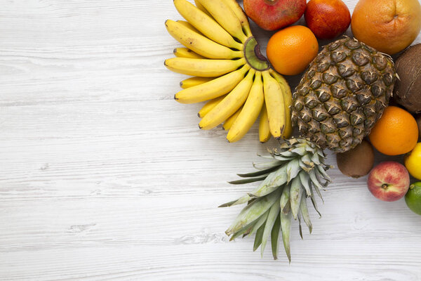 Fresh fruit on a white wooden background, from above. Copy space. Flat lay.