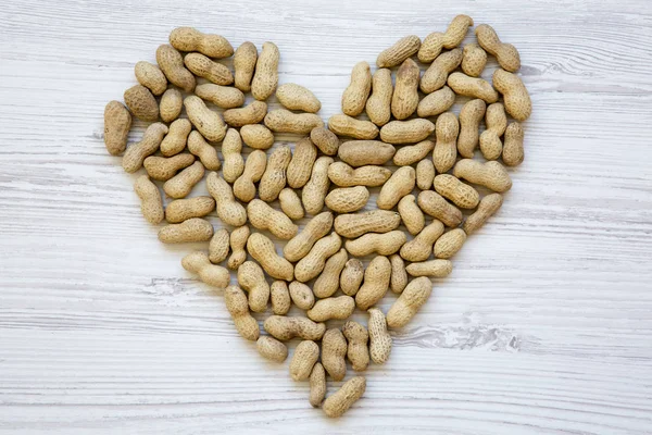 Peanuts in heart shape, top view. Flat lay. From above.
