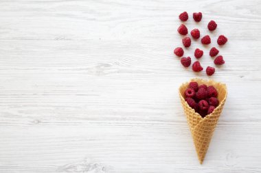 Gözleme tatlı dondurma koni ile ahududu Beyaz ahşap arka planda, üstten görünüm. Düz yatıyordu. Kopya alanı.