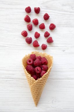 Gözleme tatlı dondurma koni ile ahududu Beyaz ahşap arka plan, üstten görünüm üzerinde. Düz yatıyordu. Yukarıdan.