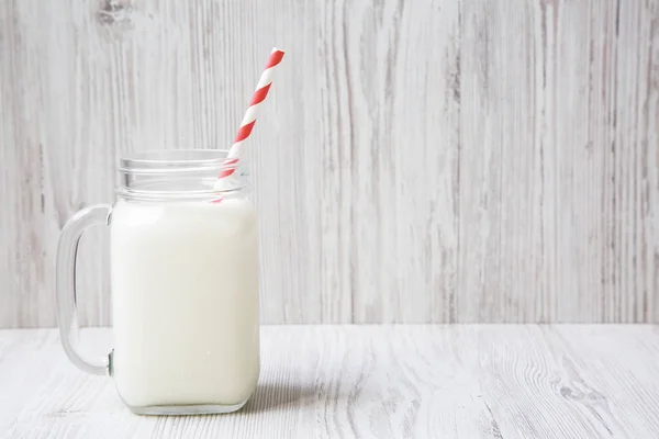 Beyaz Ahşap Zemin Üzerinde Kavanoz Soğuk Süt Yan Görünüm Portre — Stok fotoğraf