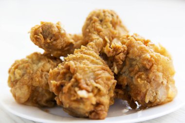 Kızarmış tavuk drumsticks beyaz tabakta yakın çekim.