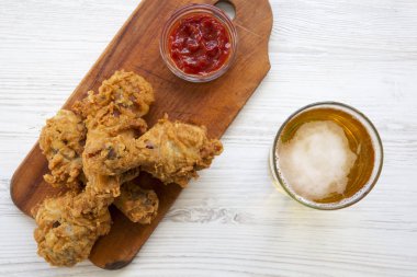Kızarmış tavuk drumsticks ketçap ve yukarıdaki soğuk bira. Üstten görünüm.