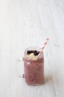 Yan görünüm, cam kavanoz ile güler yüzlü bir beyaz tahta masada. Kopya alanı.