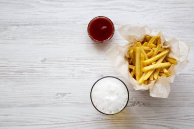 Patates kızartması sosu ve soğuk bira bir beyaz tahta yüzeyi ile üst görünüm. Yukarıdan. Kopya alanı.