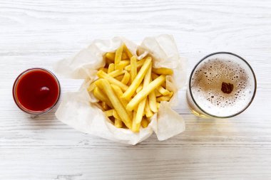 Sos ve bira bir beyaz tahta yüzeyi ile yukarıdan patates kızartması. Üstten görünüm.