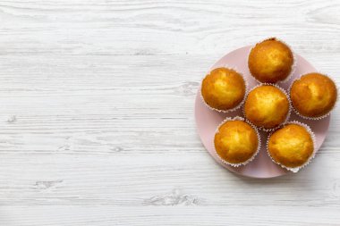 Beyaz ahşap yüzey, en iyi görünümü üzerinde pembe bir plaka üzerinde taze kek. Kopya alanı.