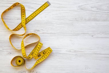 Üstten görünüm, ölçme bant Beyaz ahşap zemin üzerine sarı. Yukarıdan. Boşluk ve metin alanı Kopyala.
