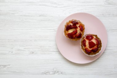 Çilek vanilya krem peynir pembe plaka üzerinde yukarıdan tarts. Kopya alanı.