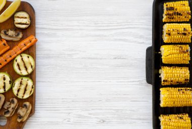 Ahşap masa, ızgara bir tavada ızgara Mısır ızgara sebze yukarıdan görüntüleyin. Beyaz ahşap arka plan. Kopya alanı.