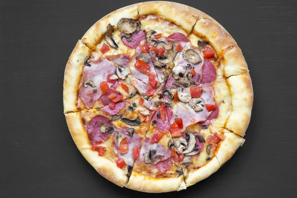 Taze pişmiş pizza siyah arka plan, üstten görünüm üzerinde. Düz, tepegöz, yukarıdan yatıyordu.