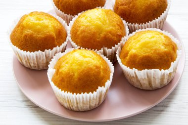 Beyaz ahşap yüzey, yan görünüm üzerinde pembe plaka üzerinde taze lezzetli kek. Yakın çekim.