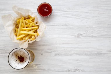 Patates kızartması sosu ve bir beyaz tahta masada soğuk bira ile yukarıdan görüntüleyin. Üstten görünüm, ek yükü. Kopya alanı.