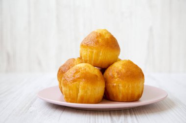 Beyaz ahşap yüzey, yan görünüm üzerinde pembe plaka üzerinde taze kek. Yakın çekim.