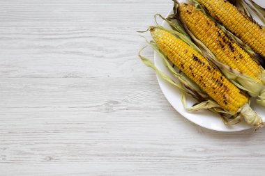 Yukarıdaki beyaz tabakta Mısır ızgara. Üstten görünüm, ek yükü. Boşluk ve metin alanı Kopyala.