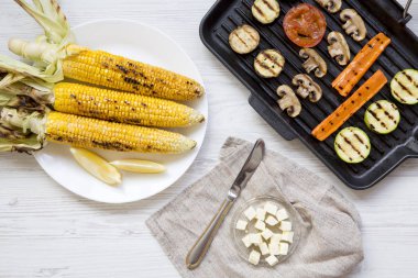 Üstten görünüm, ızgara mısır koçanı ve ızgara sebzeler.