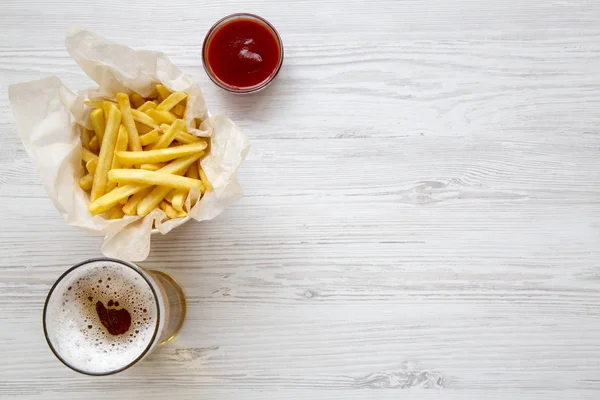 Patates kızartması sosu ve bir beyaz tahta masada soğuk bira ile yukarıdan görüntüleyin. Üstten görünüm, ek yükü. Kopya alanı.