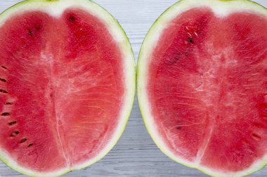 Yukarıdan, taze bir beyaz ahşap yüzeye karpuz kestim. Tepegöz, üstten görünüm. Yakın çekim.