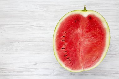 Beyaz ahşap zemin üzerinde yarım düzenlenen karpuz. Kopya alanı.