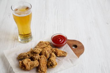 Kırmızı biber soslu tavuk kanadı soğuk bira. Yan görünüm.