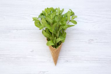 Yukarıdan tatlı dondurma koni Beyaz ahşap zemin, üzerine nane ile waffle. Üstten görünüm.