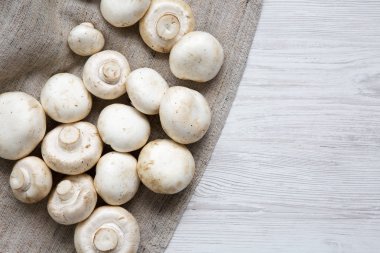 Taze champignon mantar kopya alanı ile. Beyaz ahşap arka plan. Ana sayfa görünümü, yukarıdan, ek yükü. 
