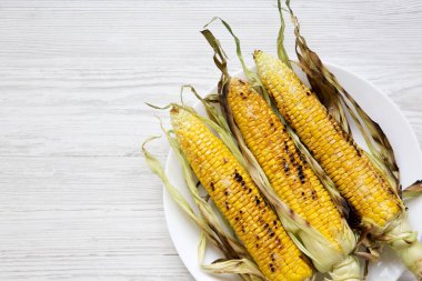 Bir beyaz üzerinde ızgara Mısır yuvarlak tabak, üstten görünüm. Yukarıdan, tepegöz, düz yatıyordu. Metin için yer.