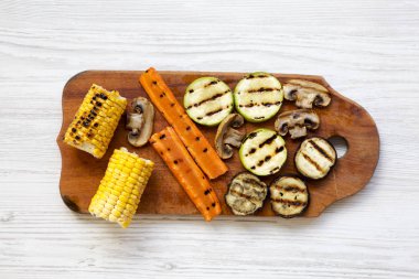 Beyaz arka plan, üstten görünüm üzerinde ahşap tahta üzerinde ızgara sebze. Düz, tepegöz, yukarıdan yatıyordu.