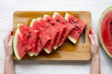 Eller bir tahta sulu karpuz, üstten görünüm dilim ile tutun. Yukarıdan.