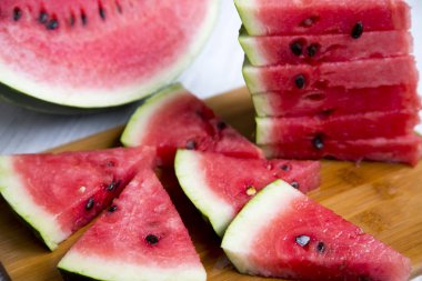 Bambu tahta üzerinde sulu karpuz dilimleri. Yan görünüm, portre.